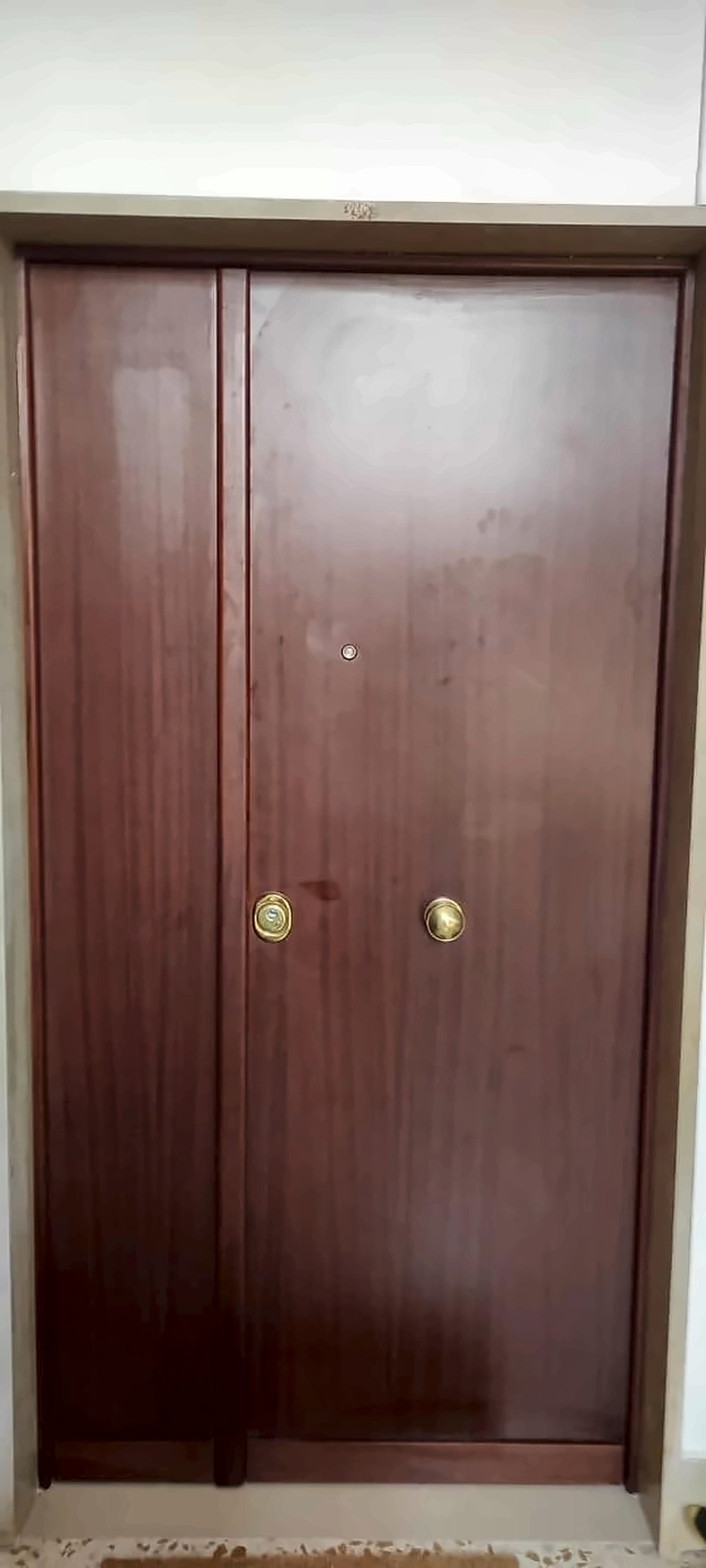 Porta blindata a due ante con rivestimento in mogano e maniglie ottone