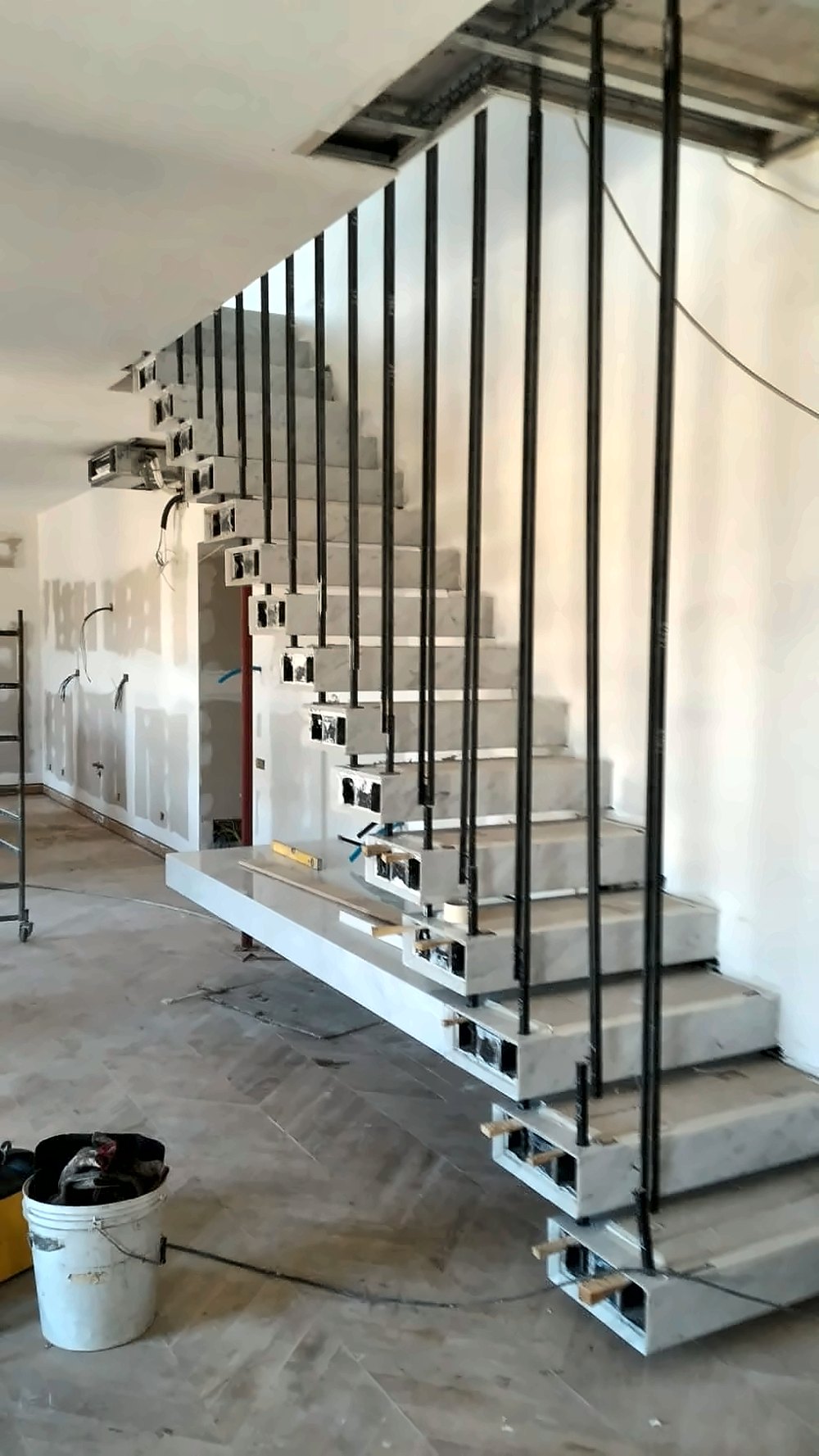 Scala sospesa con gradini in marmo e ringhiera in ferro a montanti verticali, realizzata a Salerno